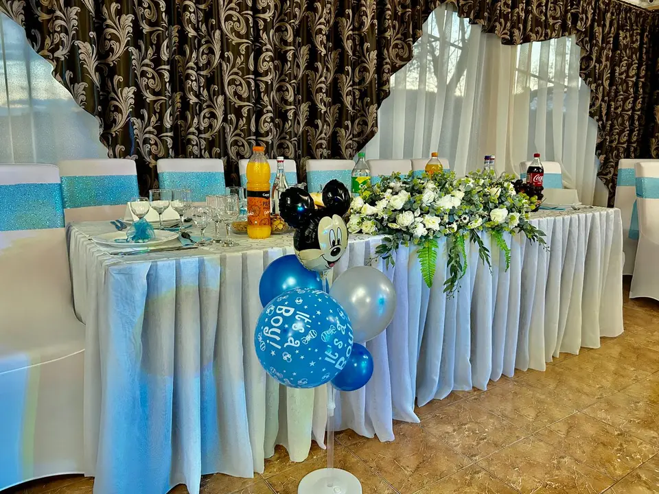 Masa principală a unui botez, în alb și albastru, cu baloane