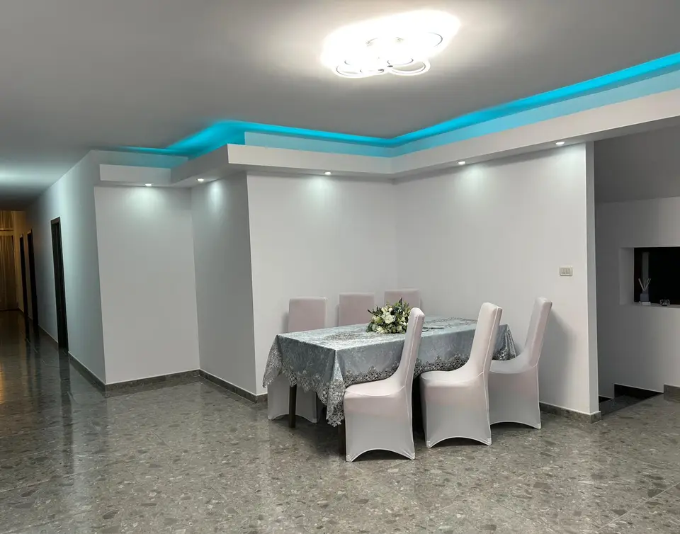 Holul renovat de la etaj, cu o masă și scaune îmbrăcate